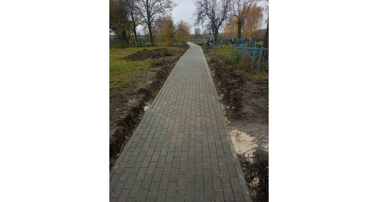 В селе Щеголек под обстрелами укладывают тротуарную плитку на кладбище